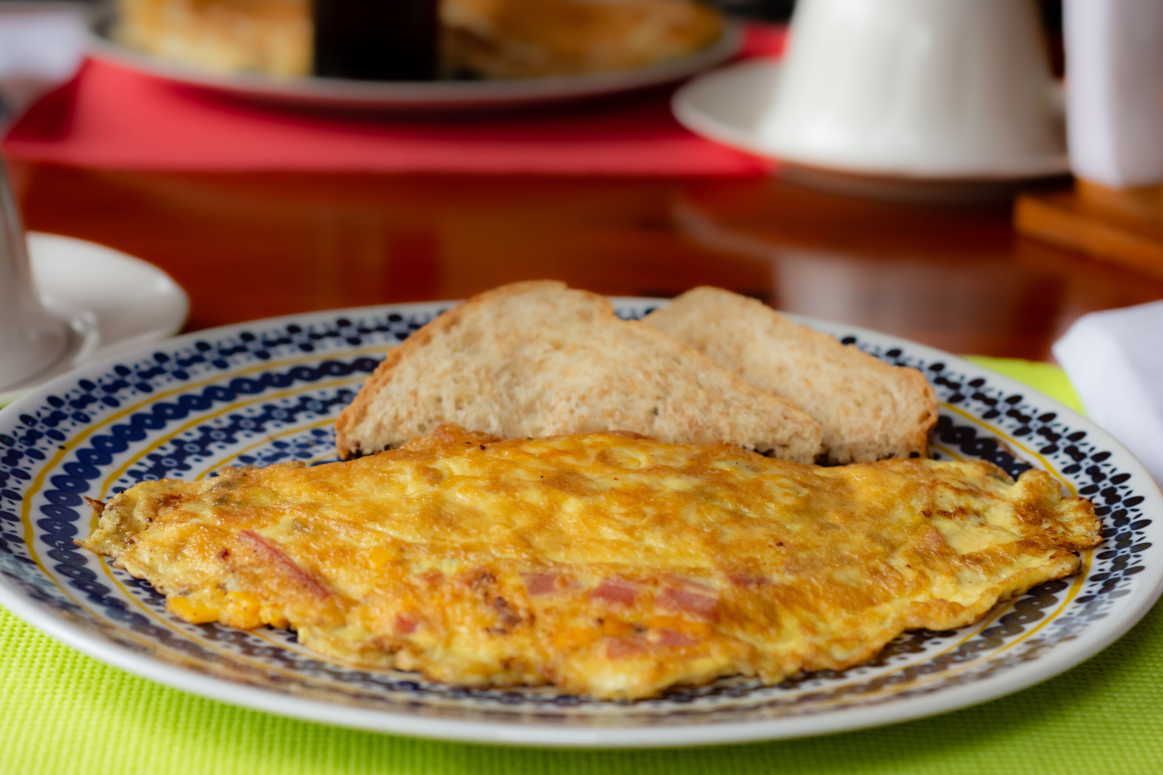 Een bord met een omelet en een sneetje toast op een decoratief bord.