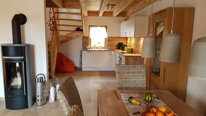 Una cocina acogedora con armarios de madera, una estufa y un comedor con una mesa lista para comer.