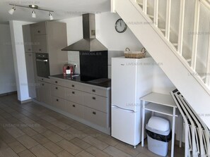 Een koelkast, kookgerei, borden en bestek