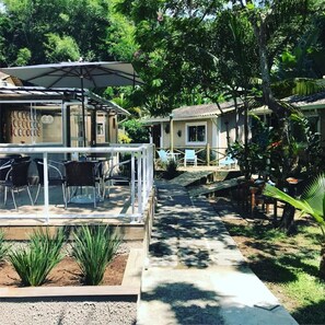 A resort with outdoor seating, a pool, and lush greenery.