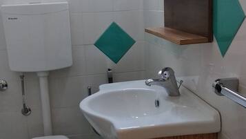 Ein Badezimmer mit Toilette, Waschbecken und Spiegel.