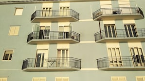 A multi-story building with balconies, windows with shutters, and a consistent architectural style. - B&B Rossini (Augusta)