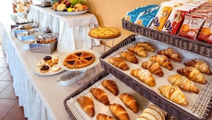 A buffet table with various food items including pastries, fruits, and condiments. - B&B Rossini (Augusta)