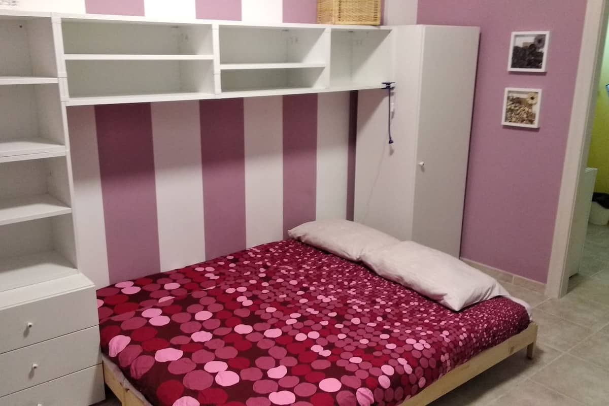 Ein Schlafzimmer mit einem Bett, einem Kleiderschrank und einem Regal.