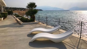 A seaside promenade with modern white loungers and a view of the sea and distant mountains. - Villa Loreley - Marina Beach Resort (Balestrate)