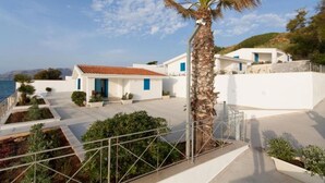 A coastal property with a white building, a palm tree, and a view of the sea. - Villa Loreley - Marina Beach Resort (Balestrate)