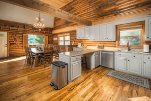A spacious kitchen with wooden cabinets, a granite countertop, and a stainless steel refrigerator. - Riverside Retreat | Private Riverfront, Hot Tub, Game Room & Fire Pit (Boone)