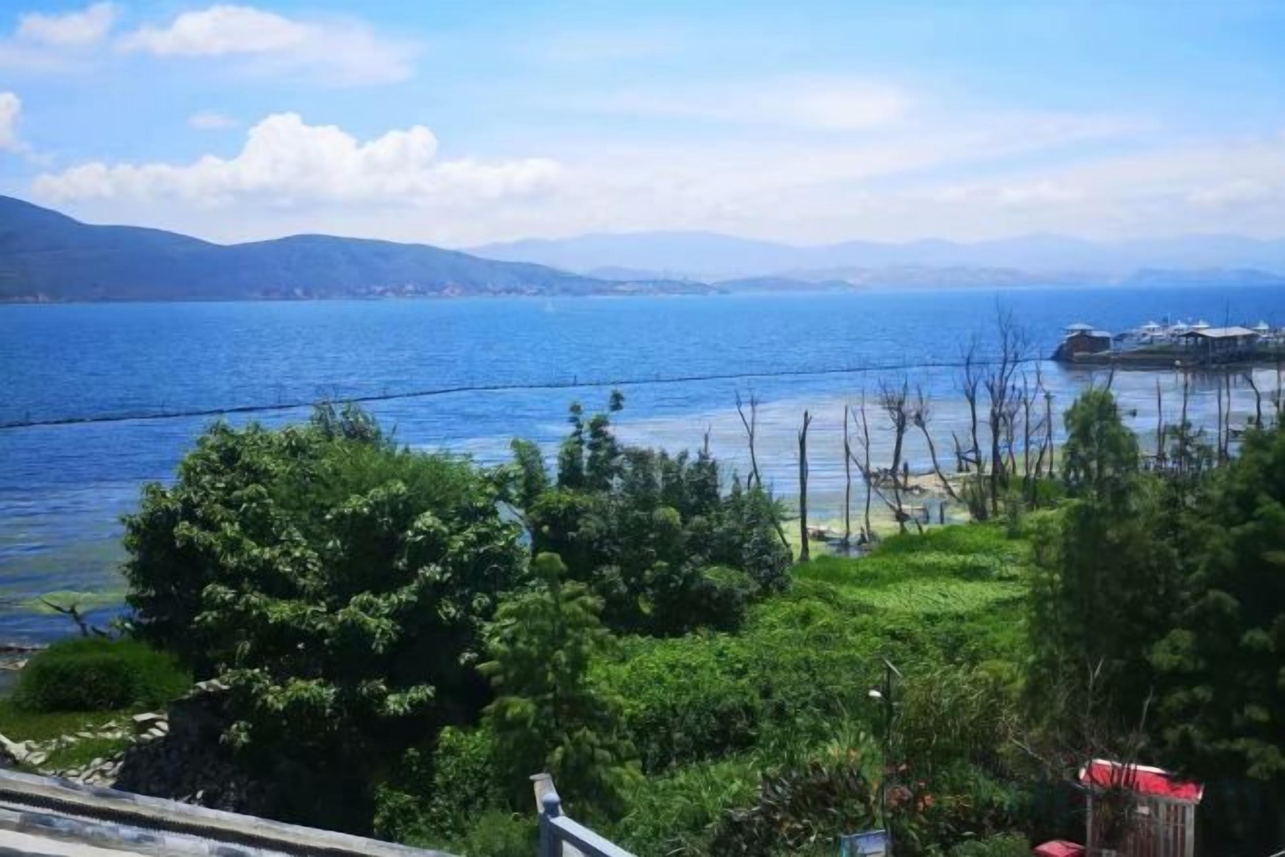 A coastal view with a clear sky, a body of water, and distant mountains.