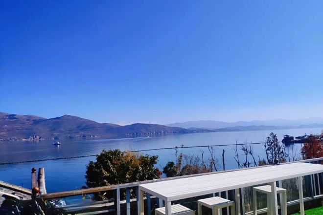 Una terraza con vistas despejadas a un lago y montañas distantes.