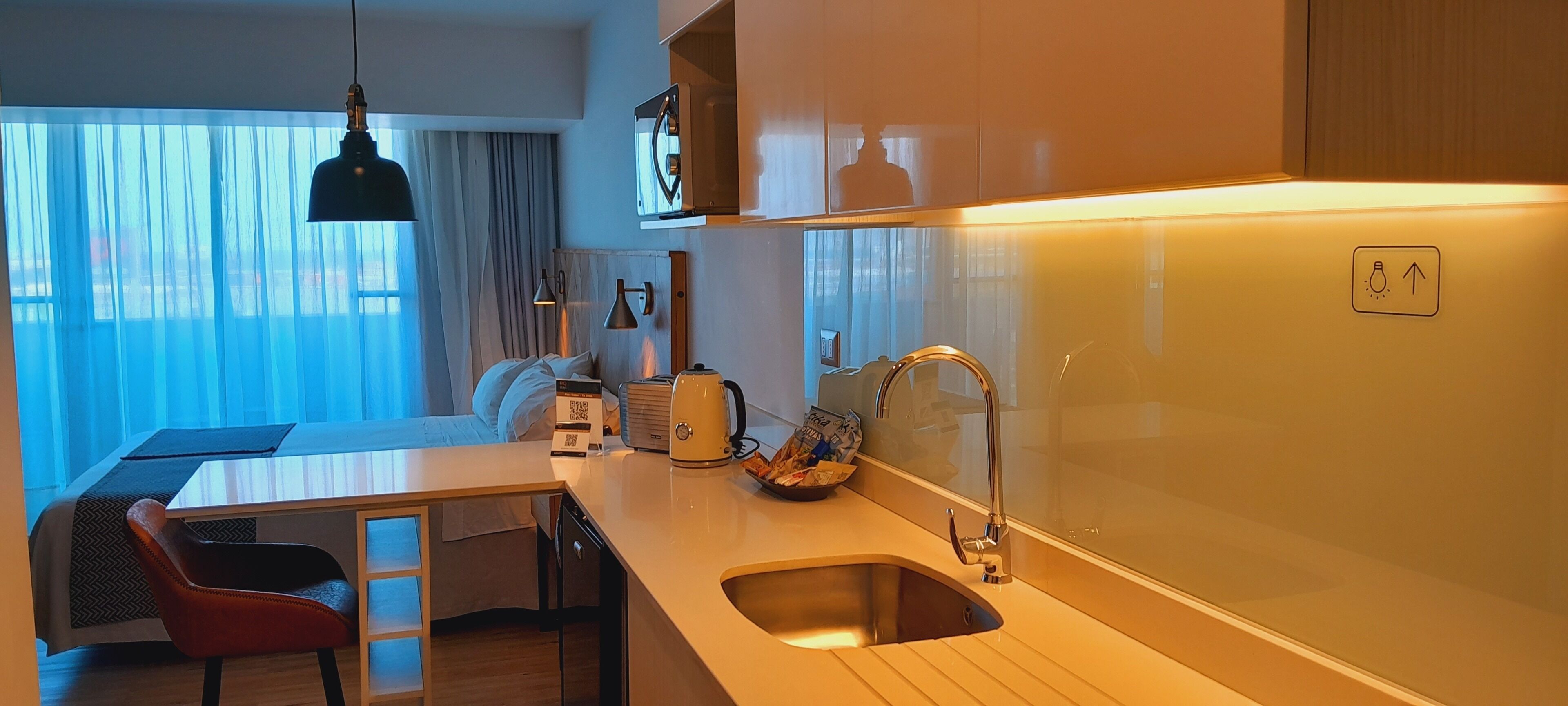 A modern kitchen with a sink, countertop, and a dining area with a table and chairs.