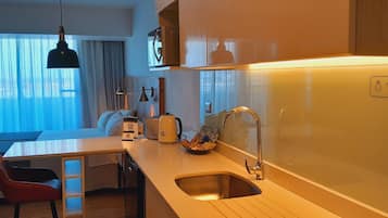 Una cocina moderna con pileta, mostrador y zona de comedor con mesa y sillas.