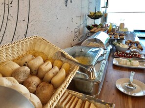A buffet with various food items including bread, cheese, and fruits.