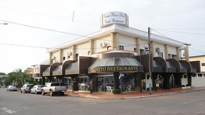 Ein zweistöckiges Gebäude mit einem Schild für „Veneto Restaurante“ und „Yemca Plaza Hotel“.