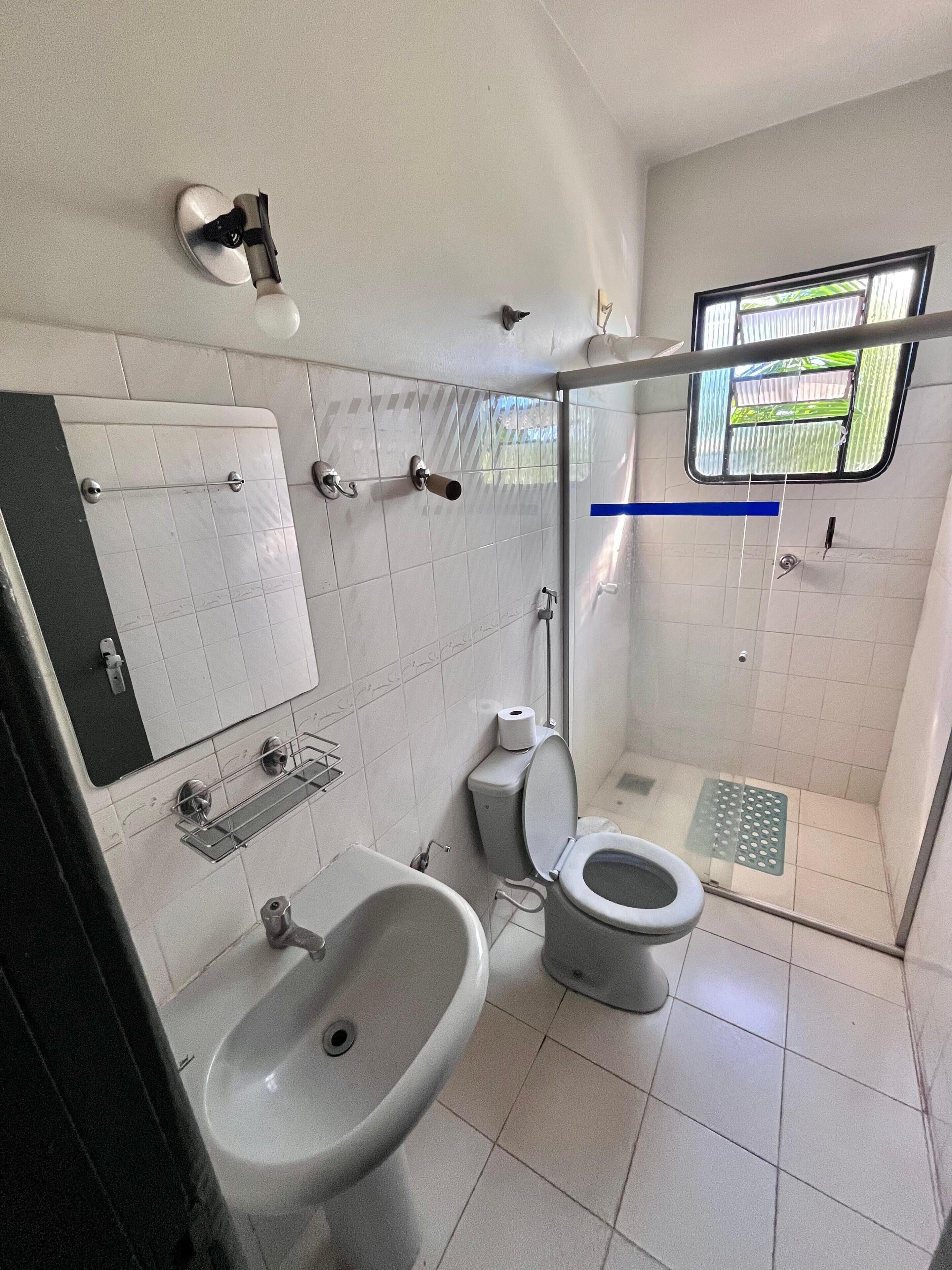 Un baño pequeño con lavamanos, inodoro y ducha.