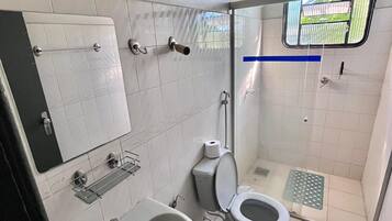 Un baño pequeño con lavamanos, inodoro y ducha.