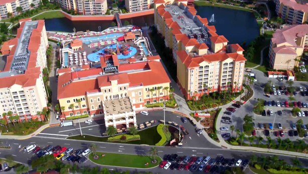 A large hotel with multiple buildings, a swimming pool, and a parking lot. - Westgate Resorts (Kissimmee)