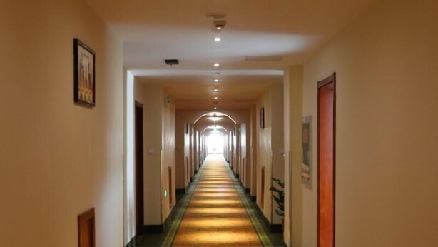 A long, narrow hotel corridor with a carpeted floor and doors on both sides. - Greentree Inn Jiangsu Changzhou Menghe Avenue Qiliang Jinfu Business Hotel (Changzhou)