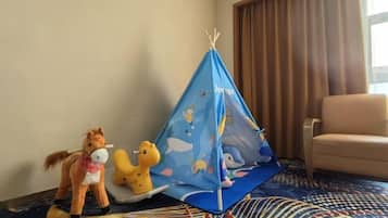 A room with a blue tent, a toy horse, and a toy dinosaur.