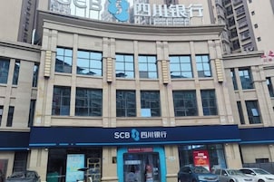 Un edificio bancario con entrada azul y señalización para SCB Sichuan Bank.