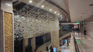 A spacious indoor area with a curved ceiling, a staircase, and a decorative light installation.