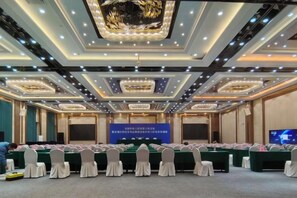 A conference room with a long table, chairs, a stage, and a screen. - Wanxing Hotel (Qu County)