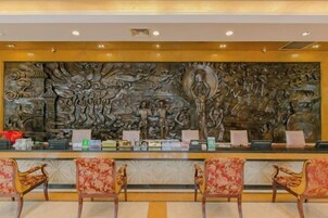 A reception area with a large decorative wall, a reception desk, and four chairs.