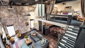 Un loft spacieux comprenant un lit en mezzanine, un coin repas et une cuisine.