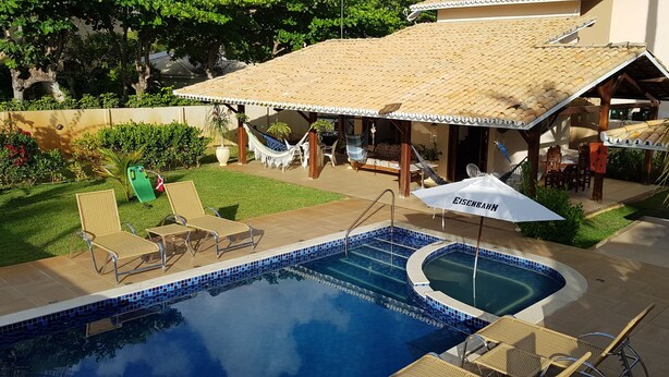 A swimming pool with lounge chairs and a covered patio area.