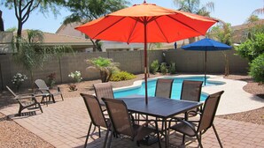 A backyard with a pool, patio furniture, and two umbrellas. - Your Backyard Oasis Waiting ..., beautiful home in an award winning community (Gilbert)