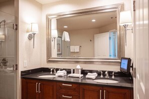 A bathroom with a large mirror, two sinks, and a digital display. - No Resort Fee Strip View Suite + Free Valet+ Pool (Las Vegas)