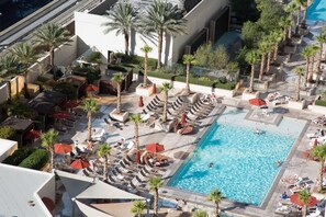 An aerial view of a resort with a swimming pool surrounded by sun loungers and palm trees. - No Resort Fee Strip View Suite + Free Valet+ Pool (Las Vegas)