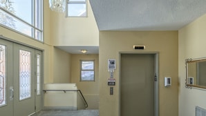 Un pasillo con una puerta, una ventana y un cartel en la pared.