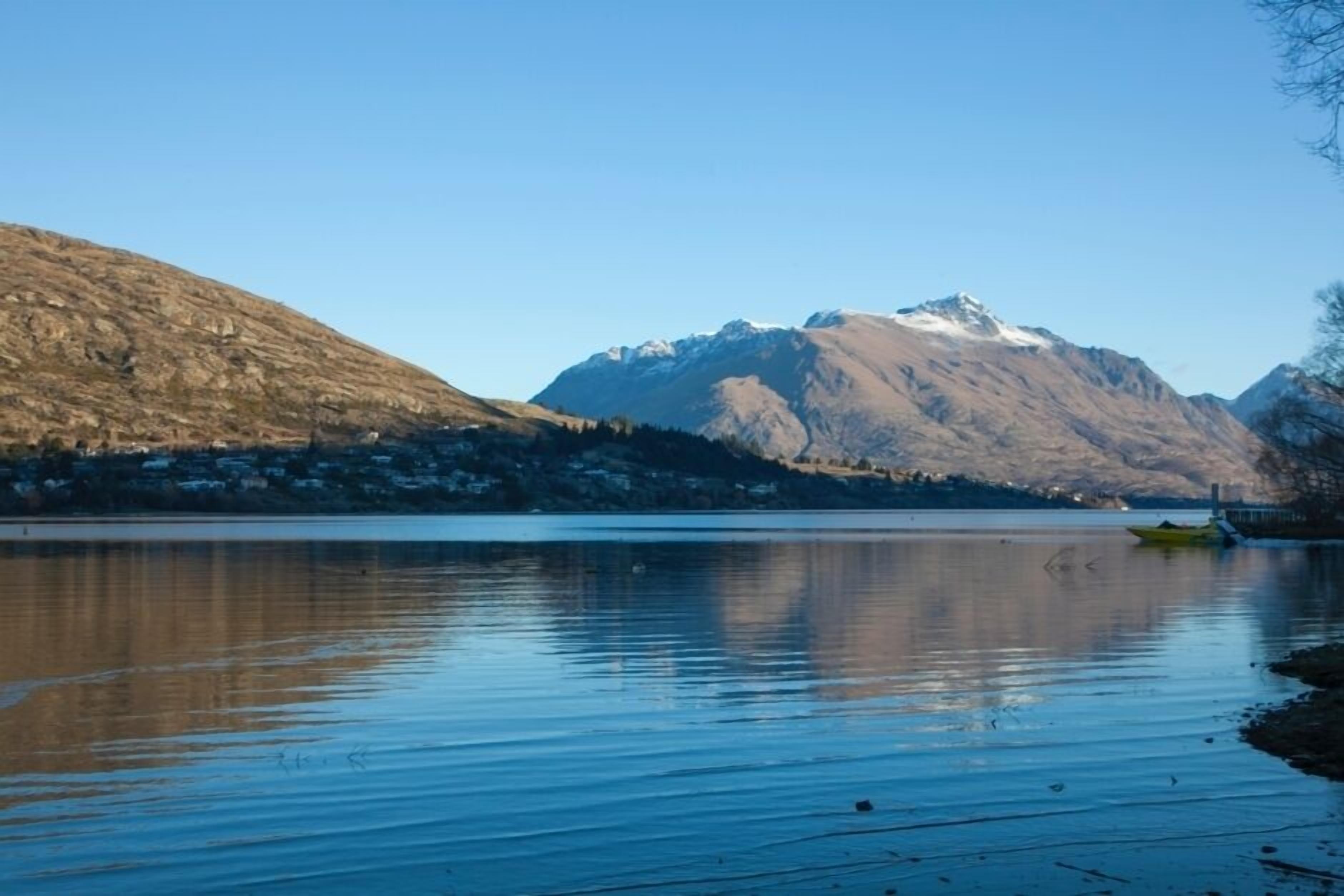Um lago tranquilo com uma montanha ao fundo.