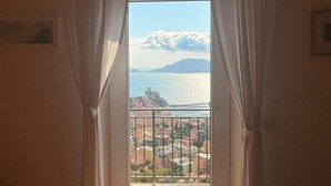 A room with a view of a coastal town through a balcony with white curtains. - Apartment 6 pax wifi breathtaking sea view (Lerici)