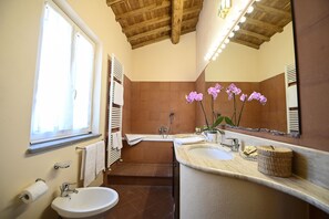 Tina con regadera, secadora de cabello, bidet, toallas 