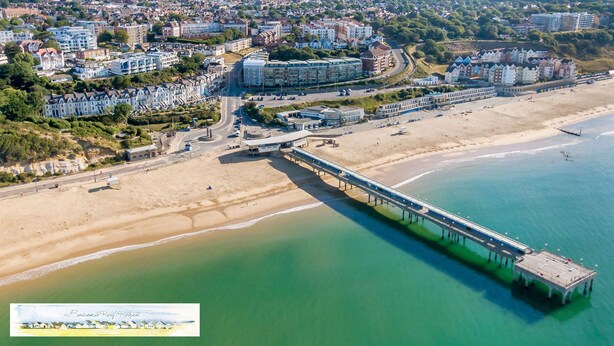 An aerial view of a coastal town with a prominent pier extending into the sea, surrounded by residential buildings and a beach. - Luxury 2BR apartment 500m from beach and close proximity to New Forest  (Boscombe, Bournemouth)