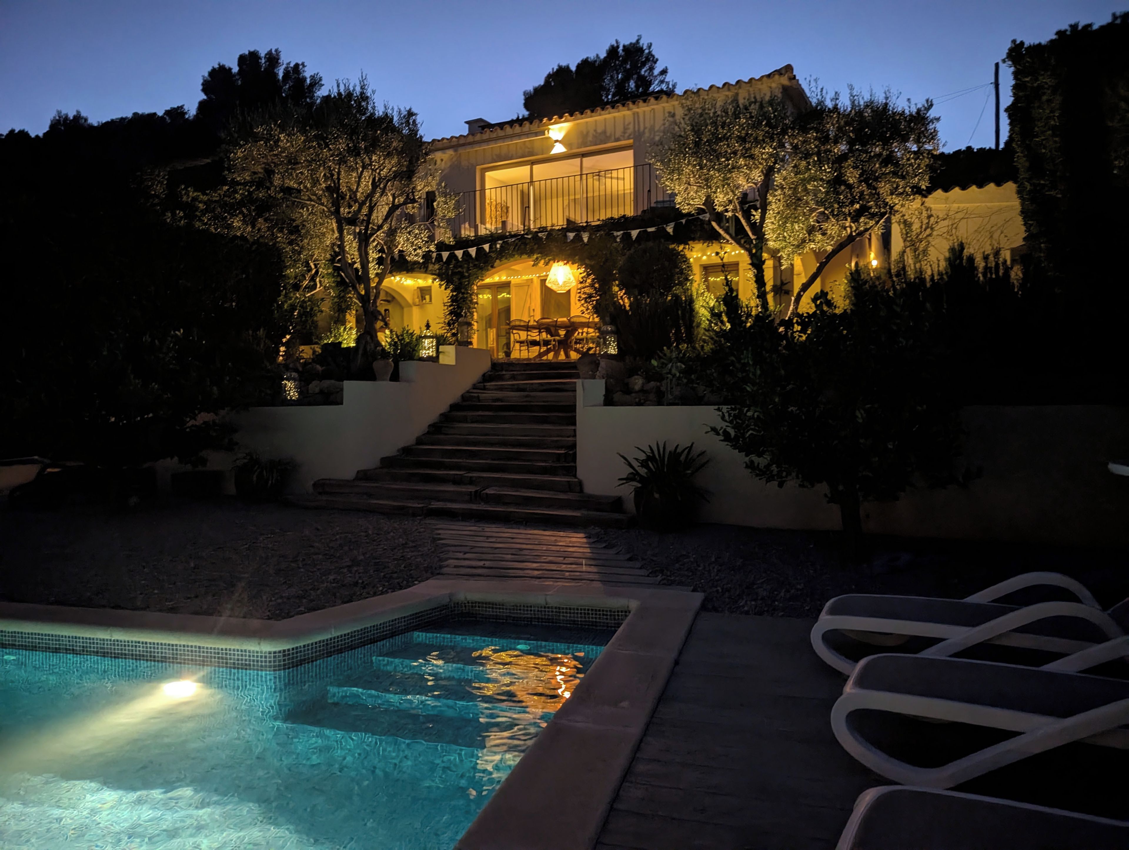 Il s’agit d’une propriété résidentielle dotée d’une piscine, d’un espace extérieur aménagé et d’un escalier menant à un balcon situé au deuxième étage.