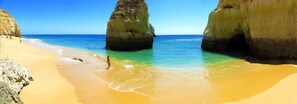 A beach with clear turquoise water, sandy shore, and large rock formations. - Luxury Villa With Private Pool And Beautiful Landscaped Garden In Gramacho Golf, (Lagoa)