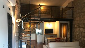 A modern interior with a staircase, a dining area, and a living room.