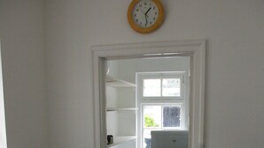A compact kitchen with a washing machine, toaster, and a clock on the wall. - Tastefully renovated, ideally located cottage for a peaceful or active break. (Cornhill-on-Tweed)