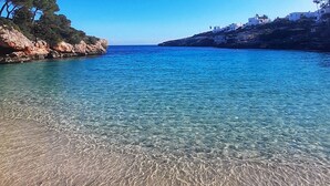A clear coastal view with rocky shores and a calm sea.