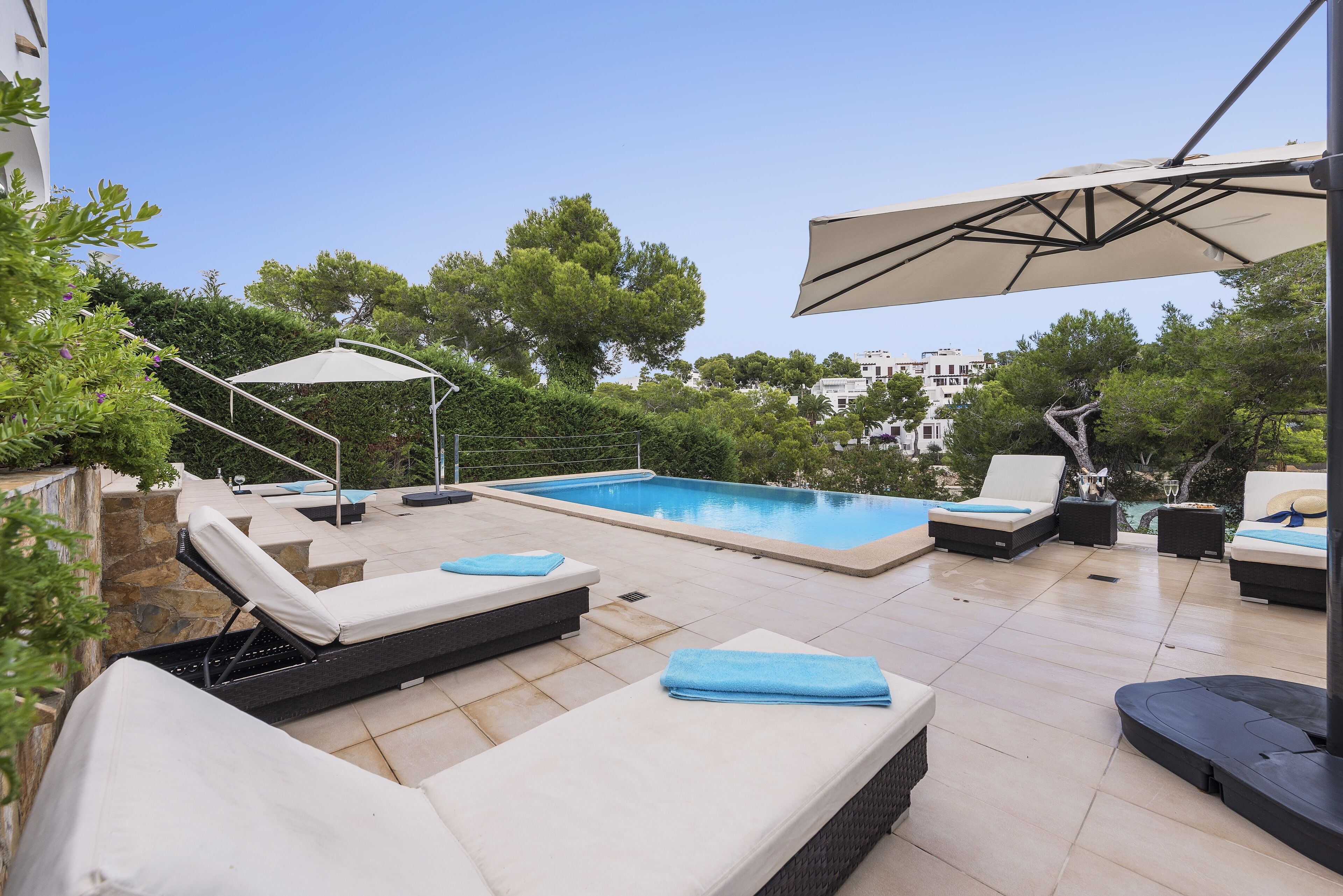 Un espace piscine aménagé sur le toit, avec des chaises longues et des parasols.