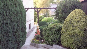A stone staircase leading up to a building, surrounded by neatly trimmed hedges and a small garden with colorful flowers. - Great basement apartment in the middle of the island of Rügen in the outskirts of a village near mountains (Parchtitz)