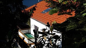 A house with a red-tiled roof, a white exterior, and a view of a lake with sailboats. - Holiday and relaxation on the Ossiacher See (Ostriach)