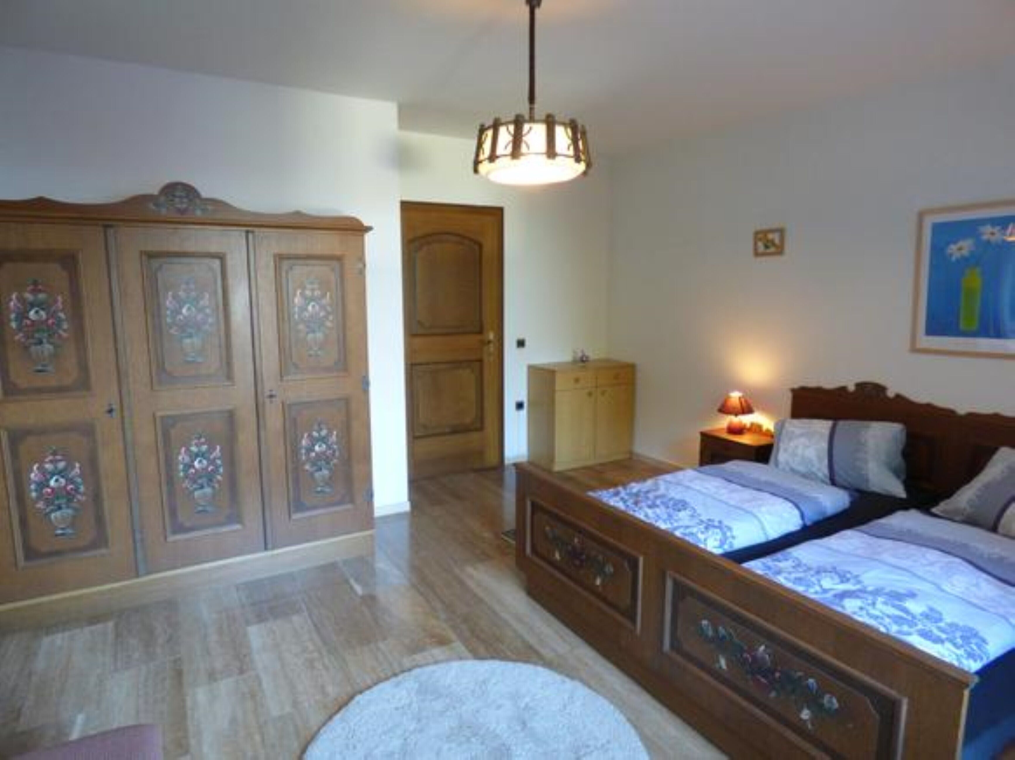 Una camera da letto con un letto in legno, un comodino, un armadio e una porta.