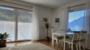 A dining area with a table and chairs, a potted plant, and a glass coffee table. - Holiday and relaxation on the Ossiacher See (Ostriach)