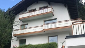 A multi-story building with a white exterior, balconies with wooden railings, and a staircase leading to the entrance marked with the number 101. - Holiday and relaxation on the Ossiacher See (Ostriach)