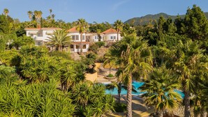 Een resort met meerdere villa's, een zwembad en weelderige begroeiing.