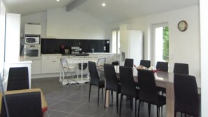 Une cuisine moderne avec des meubles blancs, un four à micro-ondes et un coin repas comprenant une table et des chaises.