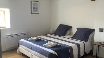 Een slaapkamer met een bed, nachtkastje en raam.